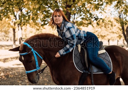 A woman is lying on a horse. Autumn horseback riding. Riding. High quality photo
