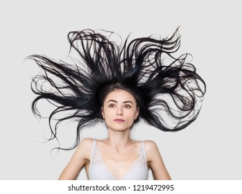 woman is lying on a light background with long flowing hair
