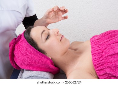 Woman lying on massage table getting acupuncture