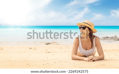 Woman lying on the sea beach enjoying and relaxing in summer
