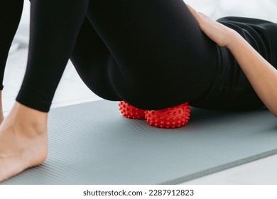 Woman lying on small balls to eliminate back pain, massage stiff muscles and lower back pain, perform exercises to relieve pain in the sacrum and spine. Relaxation and stretching of muscles - Powered by Shutterstock