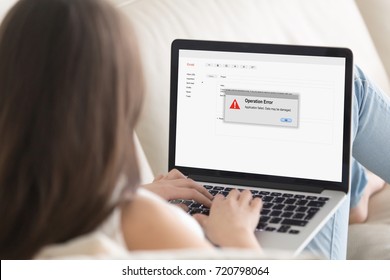 Woman Lying On Sofa Looking At Laptop Screen, Operation Error Message Pop Up. Computer Crashed, Software Failure During Web Browsing, Watching Movie, Video Call Or Chatting Via Social Media. Close Up.