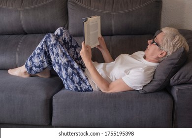 Woman Lying On The Sofa Reading A Book