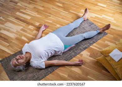 Woman lying on yoga mat after workout. Fit female relaxing on floor at home. - Powered by Shutterstock