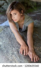 Woman Lying And Reaching Across Boulder