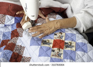 A Woman Machine Quilting/sewing Three Layers To Create A Grid Pattern On A Patriotic Quilt.