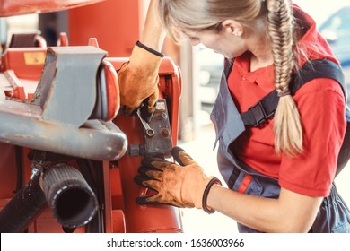 Woman Machinist Working With Wrench Of A Farm Machine Doing Some Fixing Or Maintenance