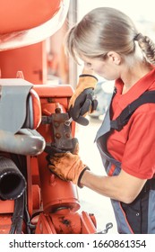 Woman Machinist Working With Wrench Of A Farm Machine Doing Some Fixing Or Maintenance