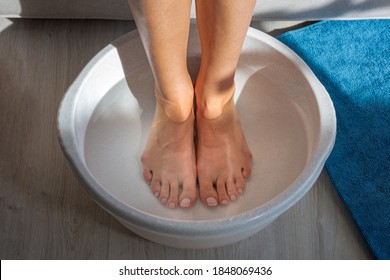 Woman made bath with hot water and baking soda for his feet. Homemade bath soak for dry feet skin - Shutterstock ID 1848069436
