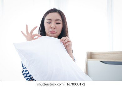 The Woman Made A Foul Face. White Pillows In The Bedroom Bed She Has To Clean To Get Rid Of Dust. Sweat Stains And Oil Deposits That Accumulate. Cleanliness Concept