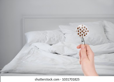 Женщина с увеличительным стеклом обнаружения постельных клопов в спальне