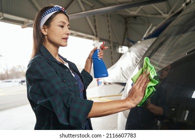 Woman Maintenance Engineer Polishing The Parts Of Aircraft In Hangar