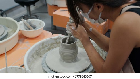 Woman make pottery wheel, shaping a clay pot - Powered by Shutterstock