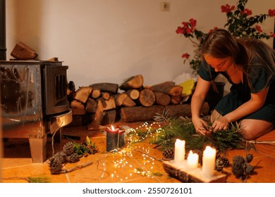 A woman makes a Christmas composition from fir branches. Women's hands create handmade Christmas decor. New Year celebration. Winter holidays. - Powered by Shutterstock