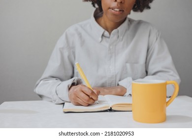 A Woman Makes A Diary Entry In The Kitchen.