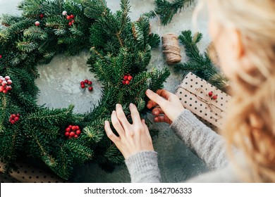 Woman makes a fir wreath for advent. Christmas Eve and crafting decorating. New Year celebration.