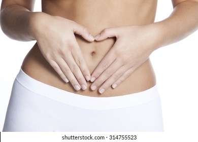 Woman makes heart shape from hands on belly. Isolated on white background