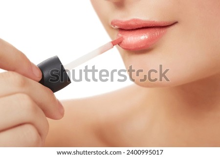 Woman, makeup and beauty with lipgloss, hand and closeup for skin, cosmetics on white background. Model, beautiful and headshot with shine, skincare or clean for facial glow, cosmetology or grooming