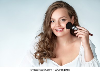 Woman With Makeup Brush. Photo Of Woman With Perfect Makeup On Light Blue Background. Beauty And Skin Care Concept. Plus Size Model.