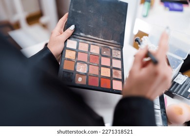 Woman and make  up palette and different mascara shades