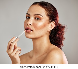 Woman, makeup portrait and lip gloss application for beauty, cosmetics dermatology and skincare wellness in grey background. Female model, face and lipstick brush or lip balm product for self care - Powered by Shutterstock