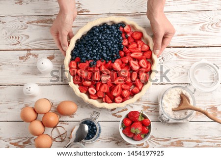 Woman making American flag pie in kitchen