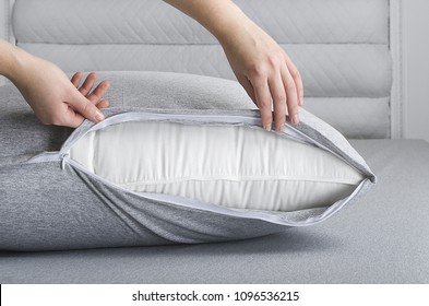 Woman Making Bed And Changing Pillow In Guest Room