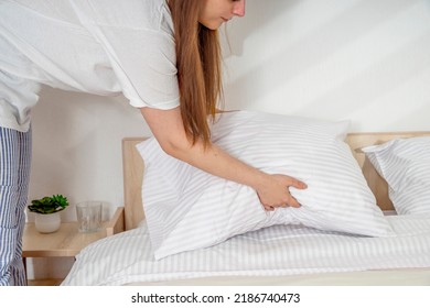 Woman Making Bed In The Morning. Bedroom Interior, Clean Linen, Bedspread, Blanket. Girl In Pajamas Holding A Pillow At The Headboard. 
