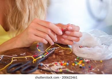 Woman Making Bracelet Of Colorful Beads With Her Hands