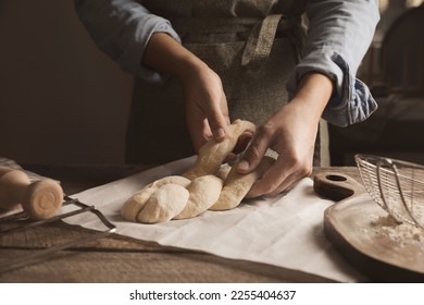 Woman making braided bread at wooden table, closeup. Traditional Shabbat challah - Powered by Shutterstock