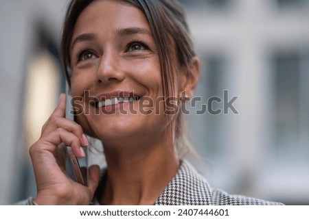 Woman making business call on cell on town street outdoors.