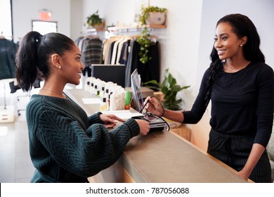 Woman Making Card Payment At The Counter In A Clothing Store