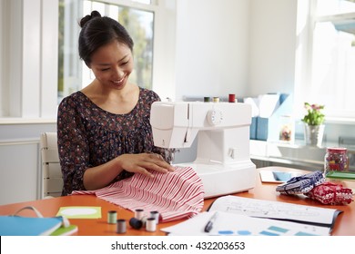Woman Making Clothes Using Sewing Machine At Home