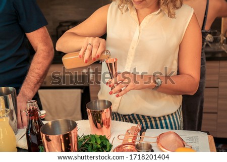 Woman making a cocktail at a home party.