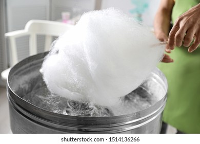 Woman making cotton candy using modern machine indoors, closeup