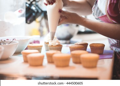 Woman making creamy top of cupcakes closeup. Selective focus. - Powered by Shutterstock
