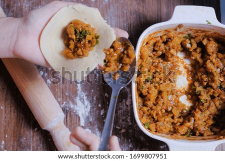 Woman making curry puff on wooden table