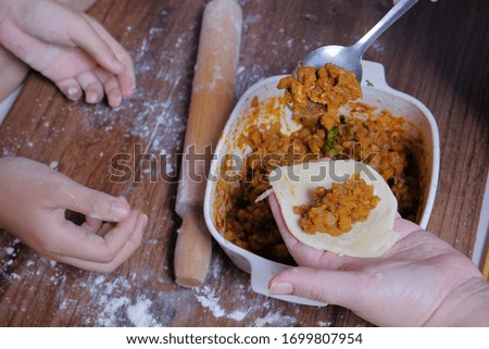 Woman making curry puff on wooden table