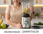 Woman making delicious smoothie with blender at white marble table in kitchen, closeup