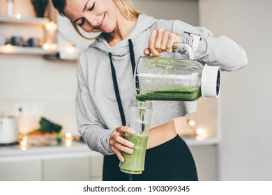 Woman Making Detox Smoothie At Home. Woman pouring smoothie to glass. healthy food concept - Powered by Shutterstock