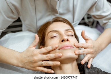 Woman Making Facial Massage At The Beauty Salon. Concept Of A Lymph Drainage Therapy