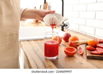Woman making fresh orange juice in kitchen - Powered by Shutterstock