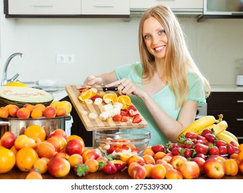 Woman Making Fruit Salad With Fruits In Home Kitchen 