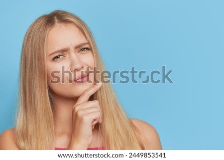 a woman is making a funny face with her hand on her chin