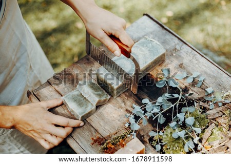 Woman is making handmade natural soaps on an old wooden table