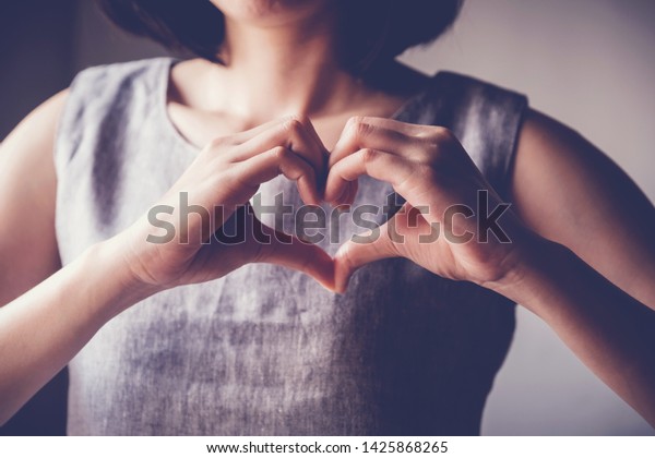 Woman making hands in heart shape, heart health\
insurance,social responsibility, gratitude,donation, happy charity\
volunteer, world heart day,  appreciation concept, world mental\
health day