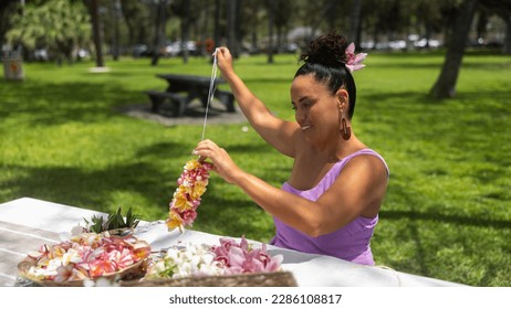 Woman making Hawaiian Lei and Hahu. Process of Handmade flower crown made from Hawaii flower Plumeria.