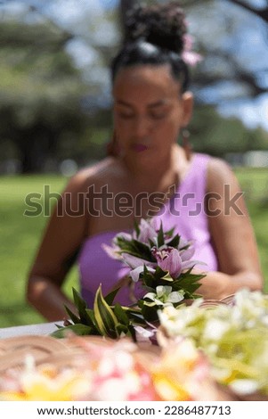 Woman making Hawaiian Lei and Hahu. Process of Handmade flower crown made from Hawaii flower Plumeria.