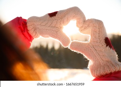 Woman Making Heart With Hands Outdoors At Sunset, Closeup. Winter Vacation