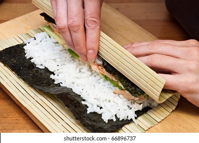 Woman Making At Home Japanese Sushi Rolls.